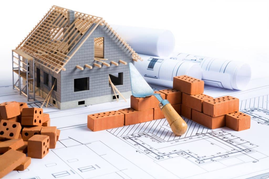 Maqueta de una vivienda en construcción con materiales y planos